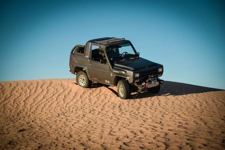 an suv in the desert on sand dunes