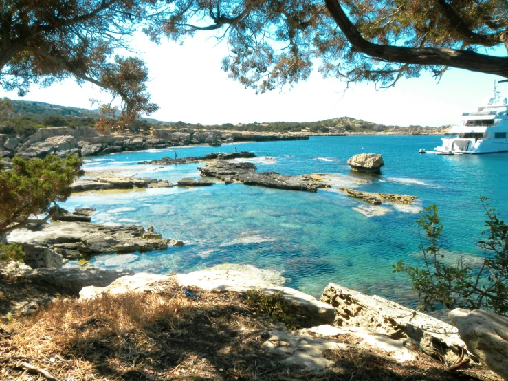 a rocky shore with a boat floating in the water