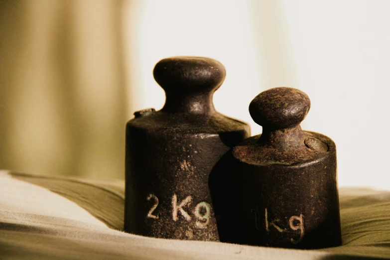 a couple of black oil bottles sitting on top of an open book