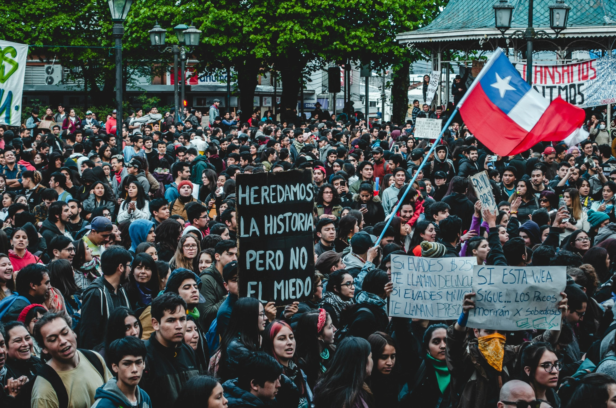 several people standing with a banner and a red and white sign