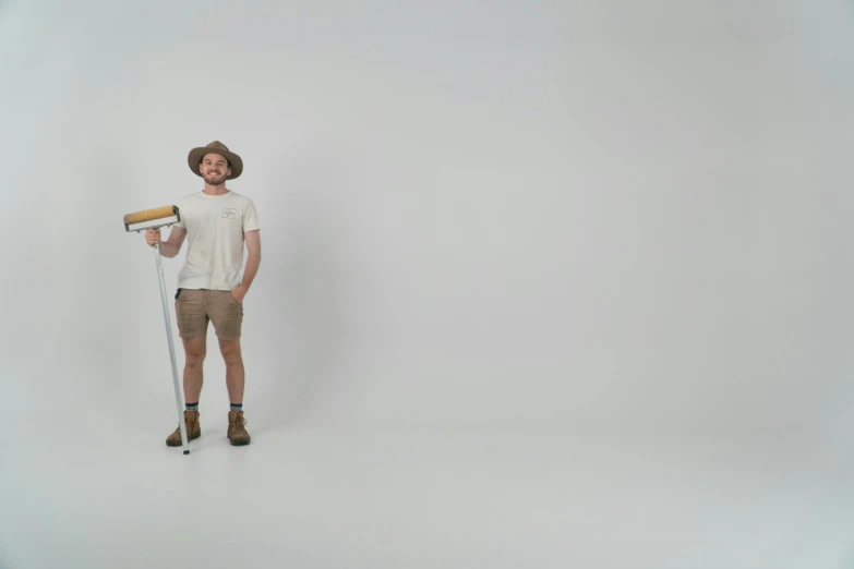 a young man holding a pair of brushes on a white background