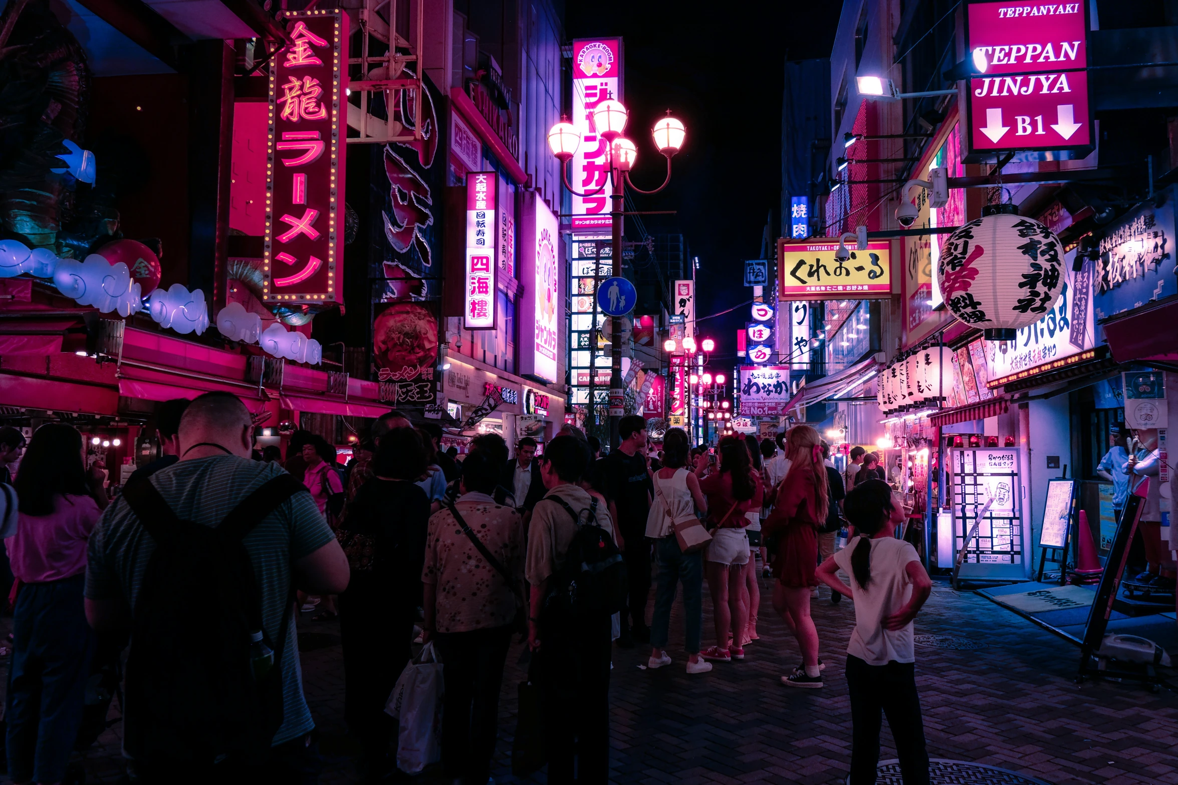 people standing in the street at night with neon signs