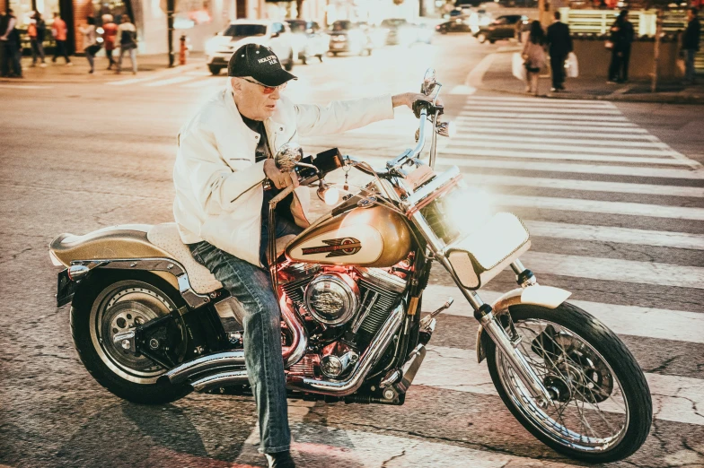 a man on a motorcycle stops at a crosswalk