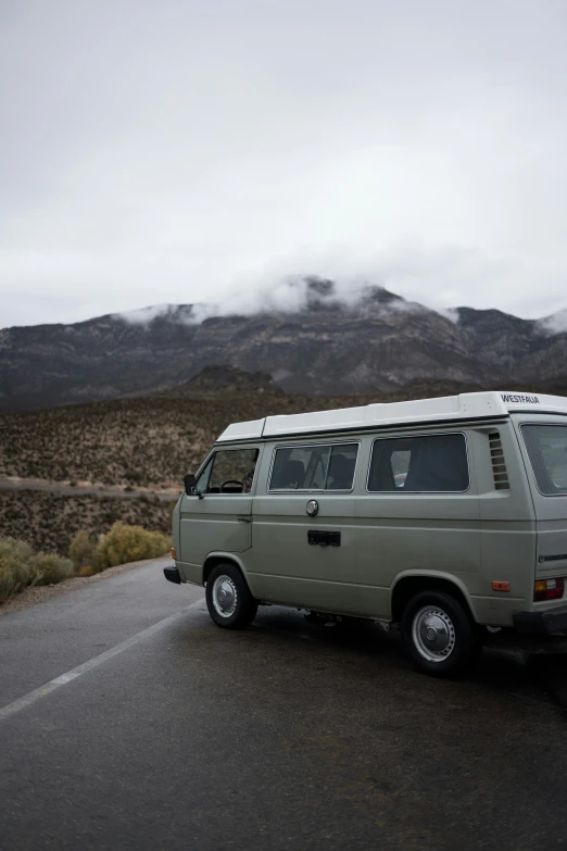 a van sitting next to the road on a cloudy day