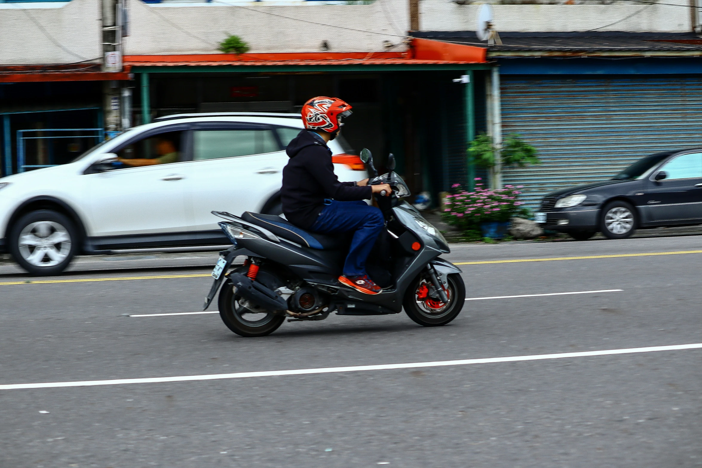 two people are riding a scooter with a helmet on it