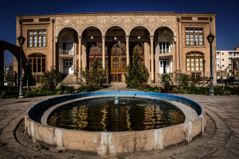 a pool of water sits in front of a large, ornate building