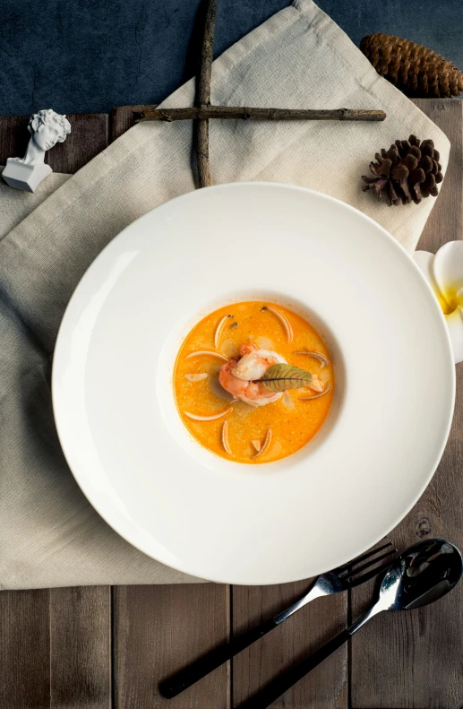 a white bowl filled with a soup and spoon on top of a table