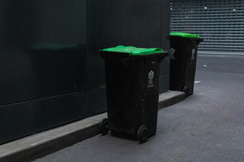 two black trash cans in front of a building