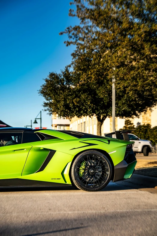 a lime green sports car parked in front of some trees