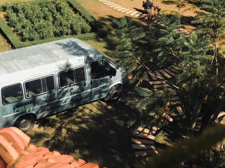 a white van is parked in a forest next to a tree