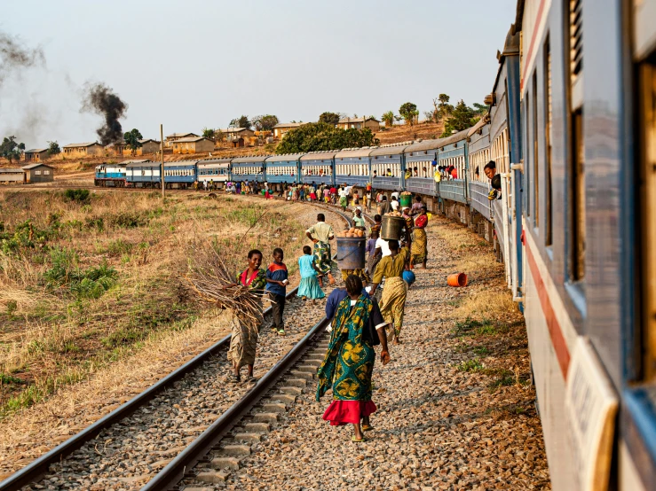 a group of people walking around on a train track