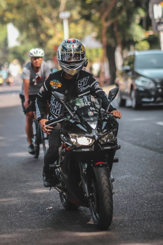 a man riding a motorcycle while riding another man on the back