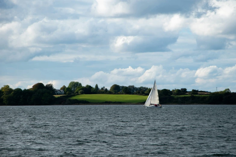 a sail boat floating on top of a large lake