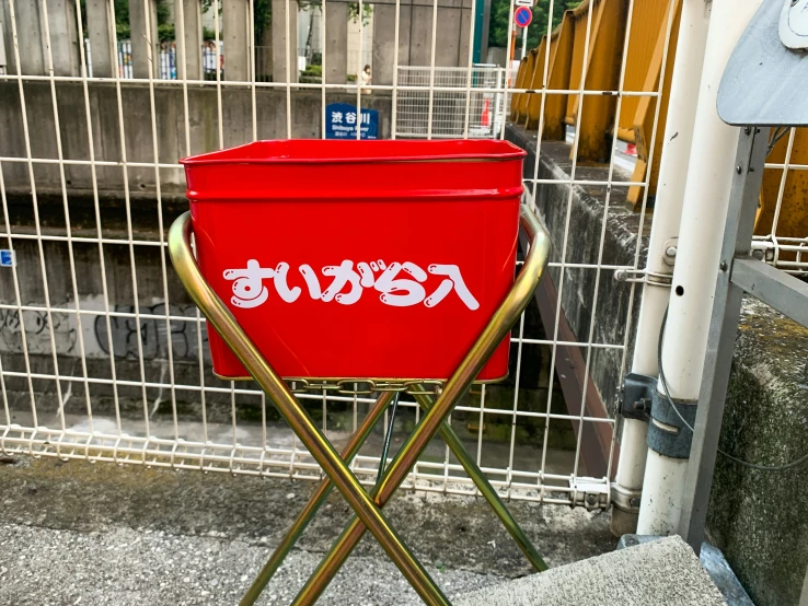 a large red cooler that is standing on a small chair