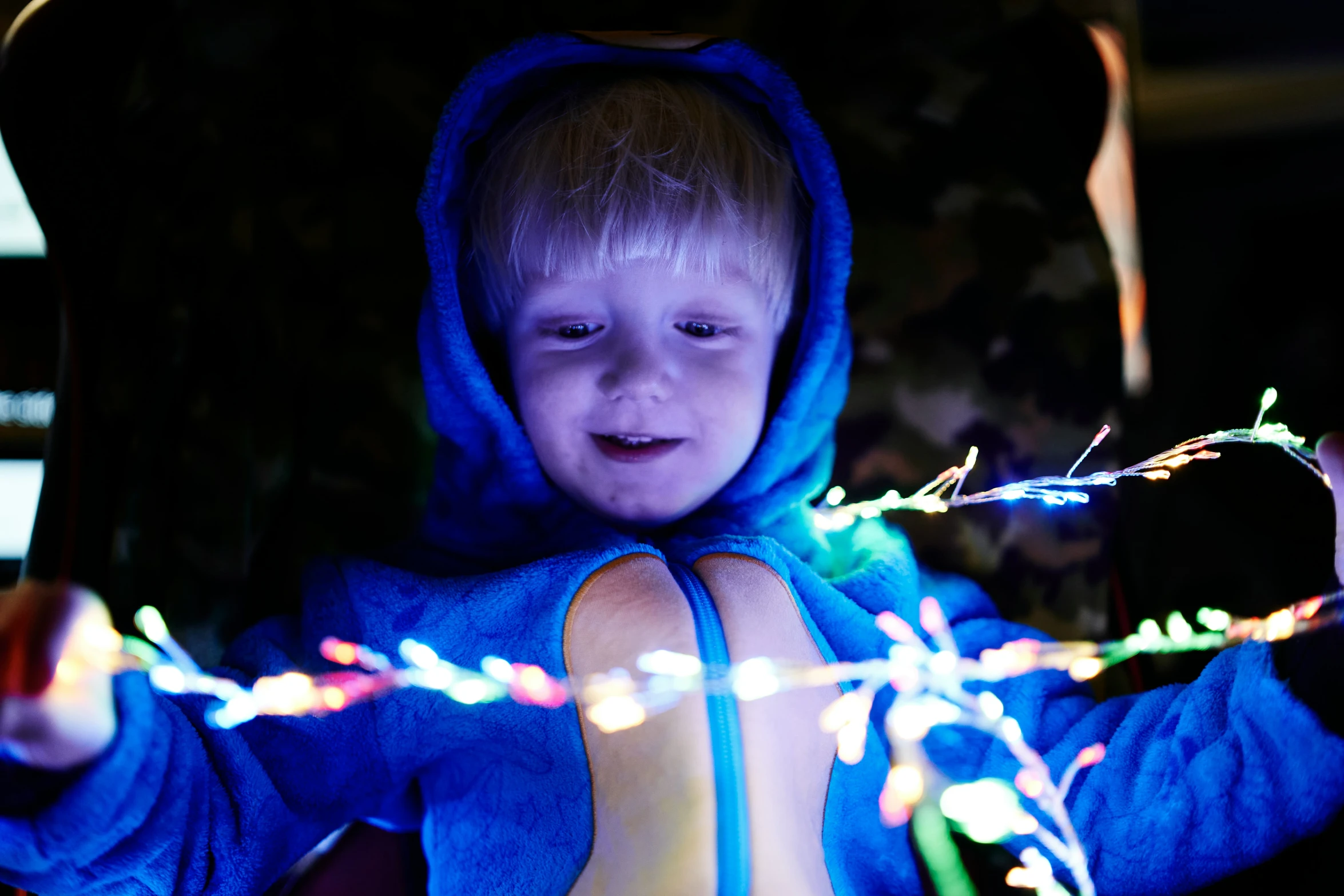 a small child dressed in blue holds on to a string