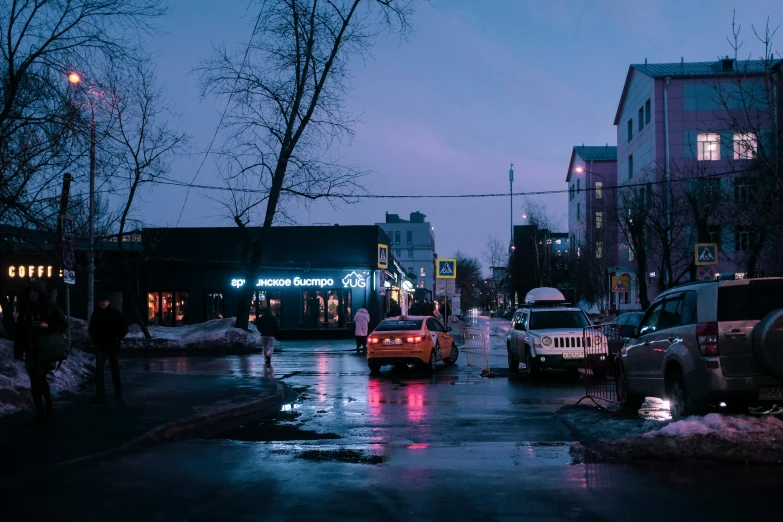 several vehicles and people are on the road at night