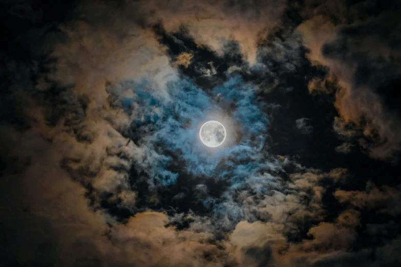 a half moon seen through dark clouds during the day