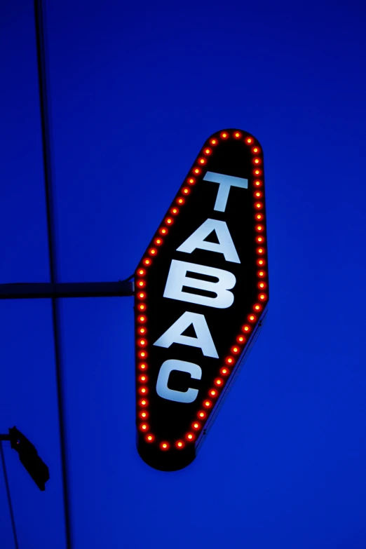 a large sign is lit up against a blue background