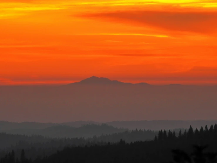 a view of mountains with trees in the foreground