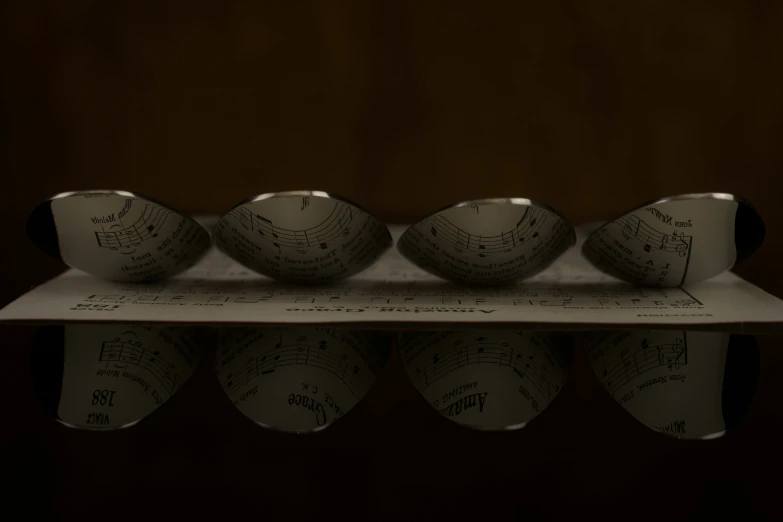 four small white bowls that are on top of a piece of paper