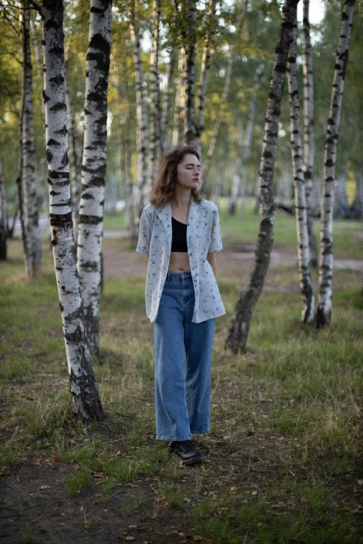 a woman standing in front of trees with her shirt off