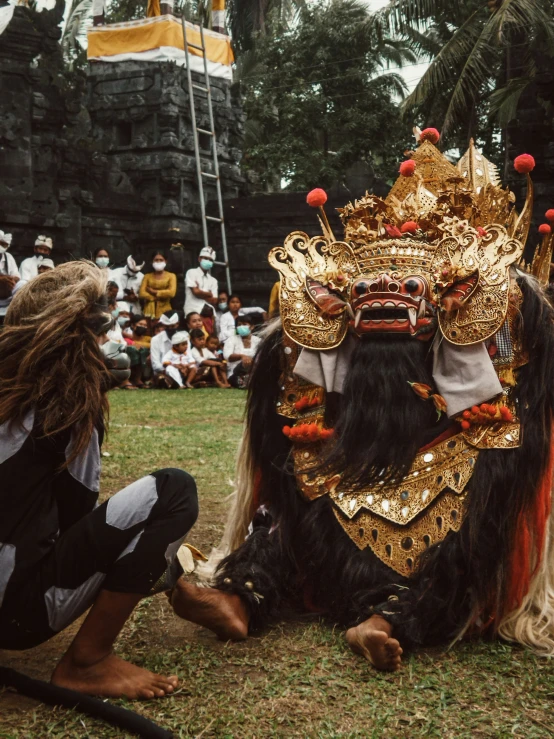 the costumed man with the beard sits on the ground