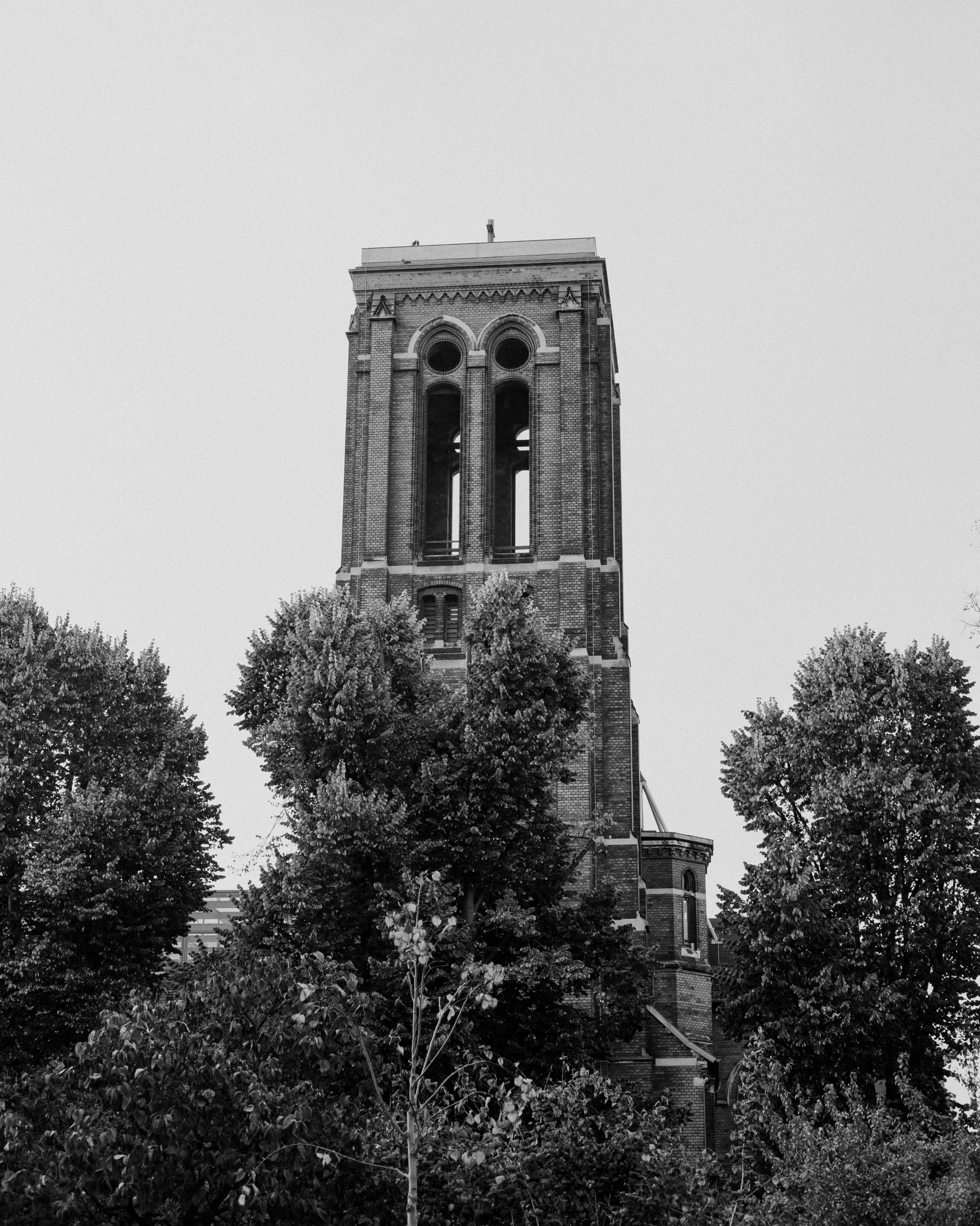 a large clock tower next to several trees