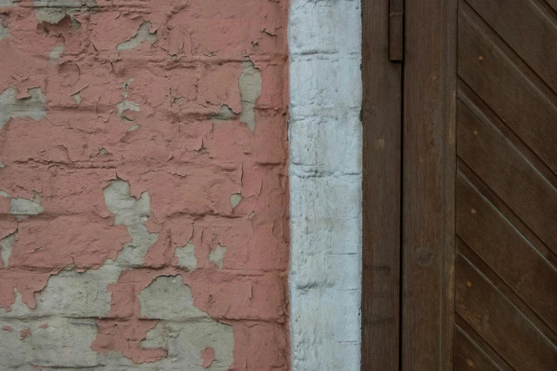 a building with peeling paint on it and closed wooden doors