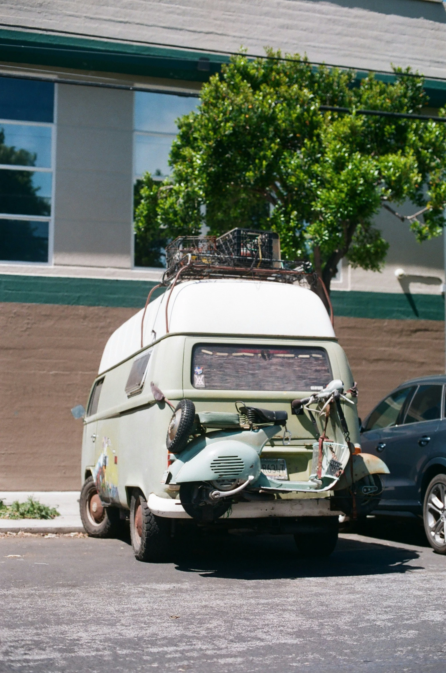 a small green and white van with luggage strapped to the front