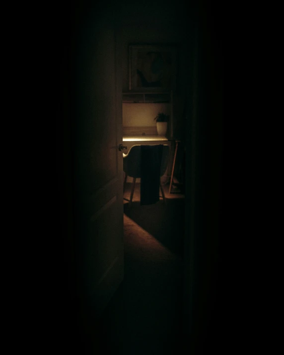 person looking in a darkened room, only at their side