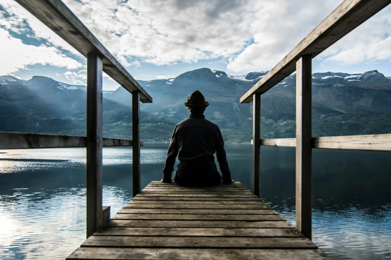 a person sitting on top of a pier