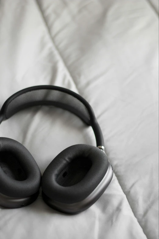 a pair of headphones lie atop a bed