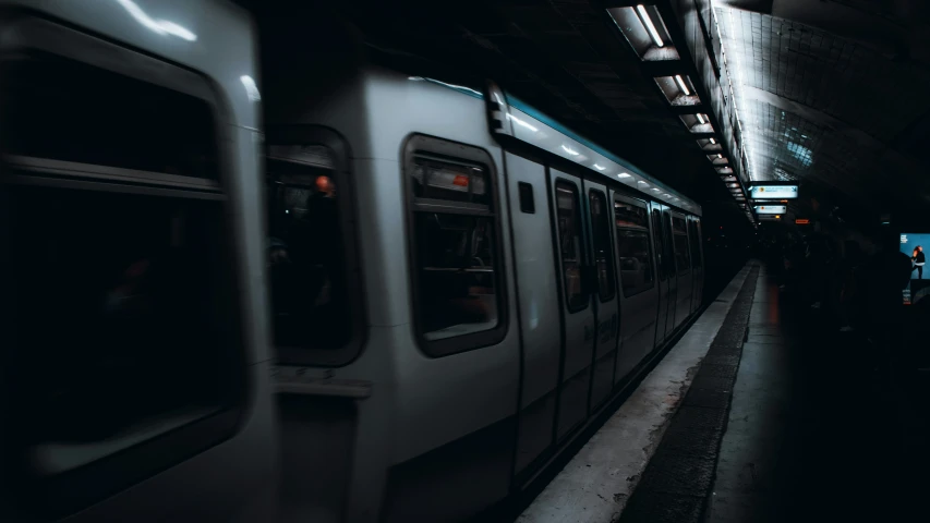 a subway train pulling into a station at night