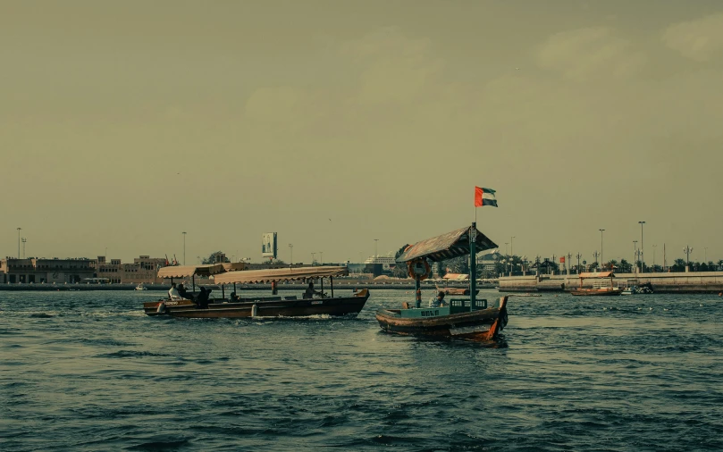 several boats floating in the water near a pier