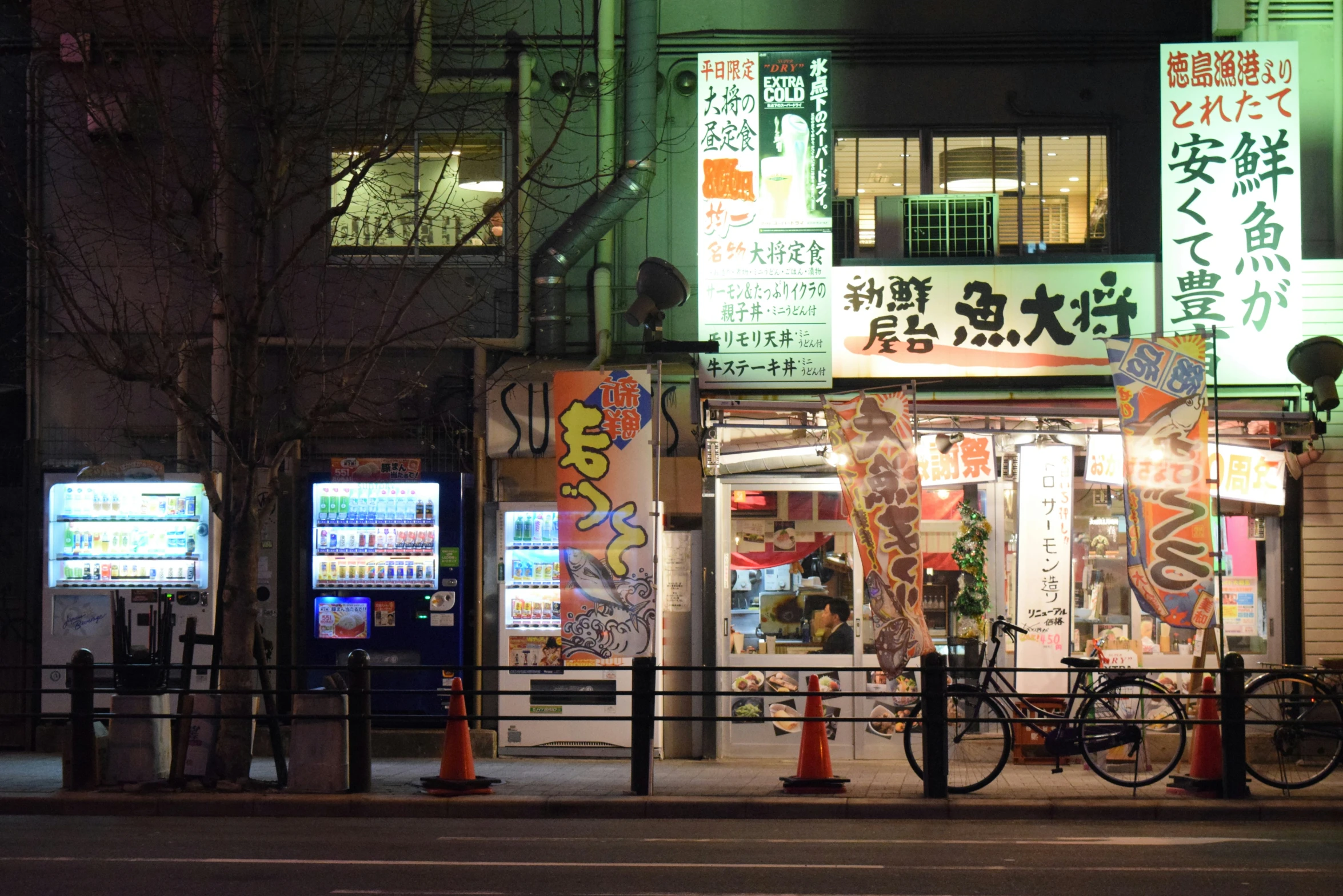 an oriental looking street corner in a city at night