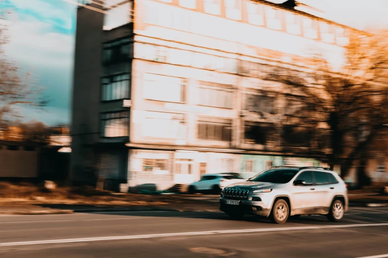 a car travels by a tall building in the city