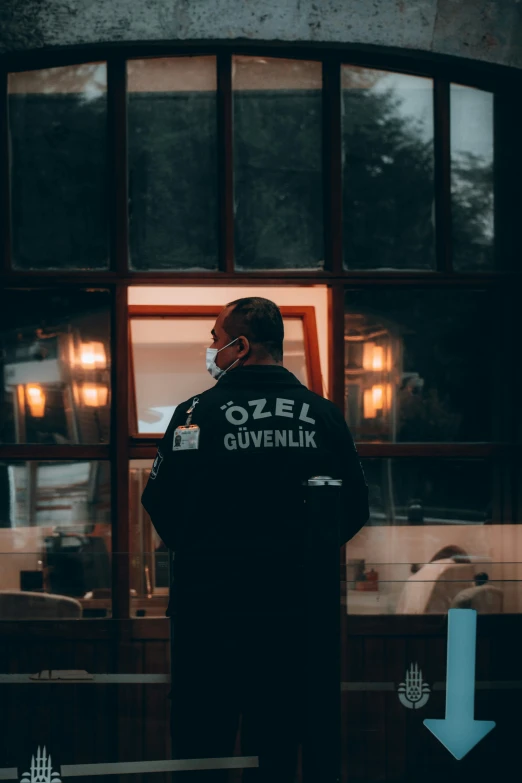 a man standing in front of a restaurant window with a face mask