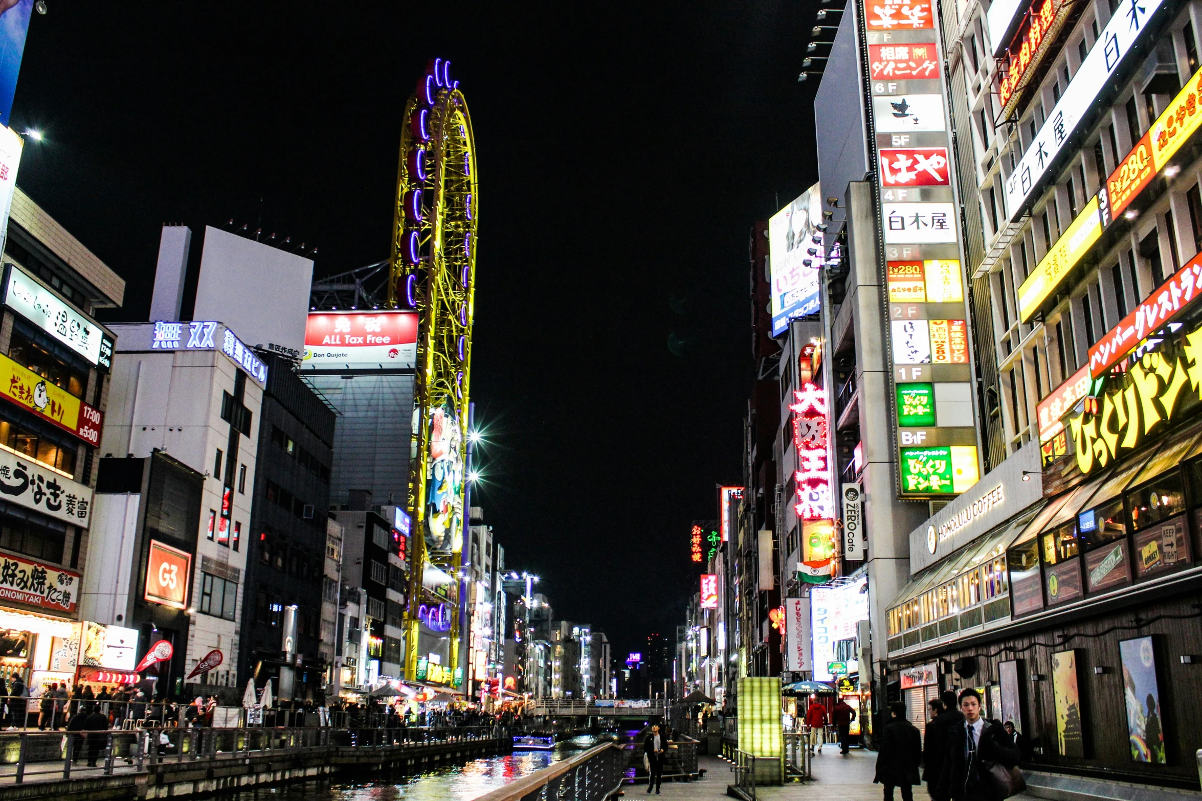 a couple of people are walking around in a city at night