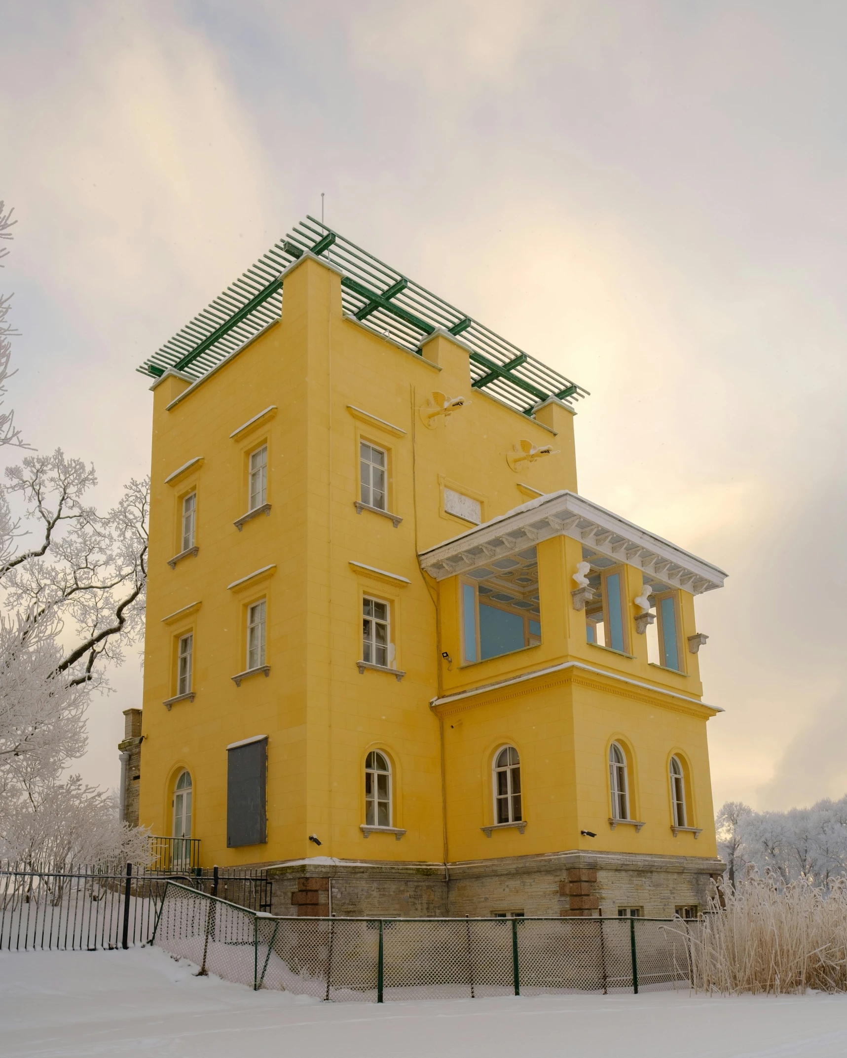 there is a yellow building that has green roof