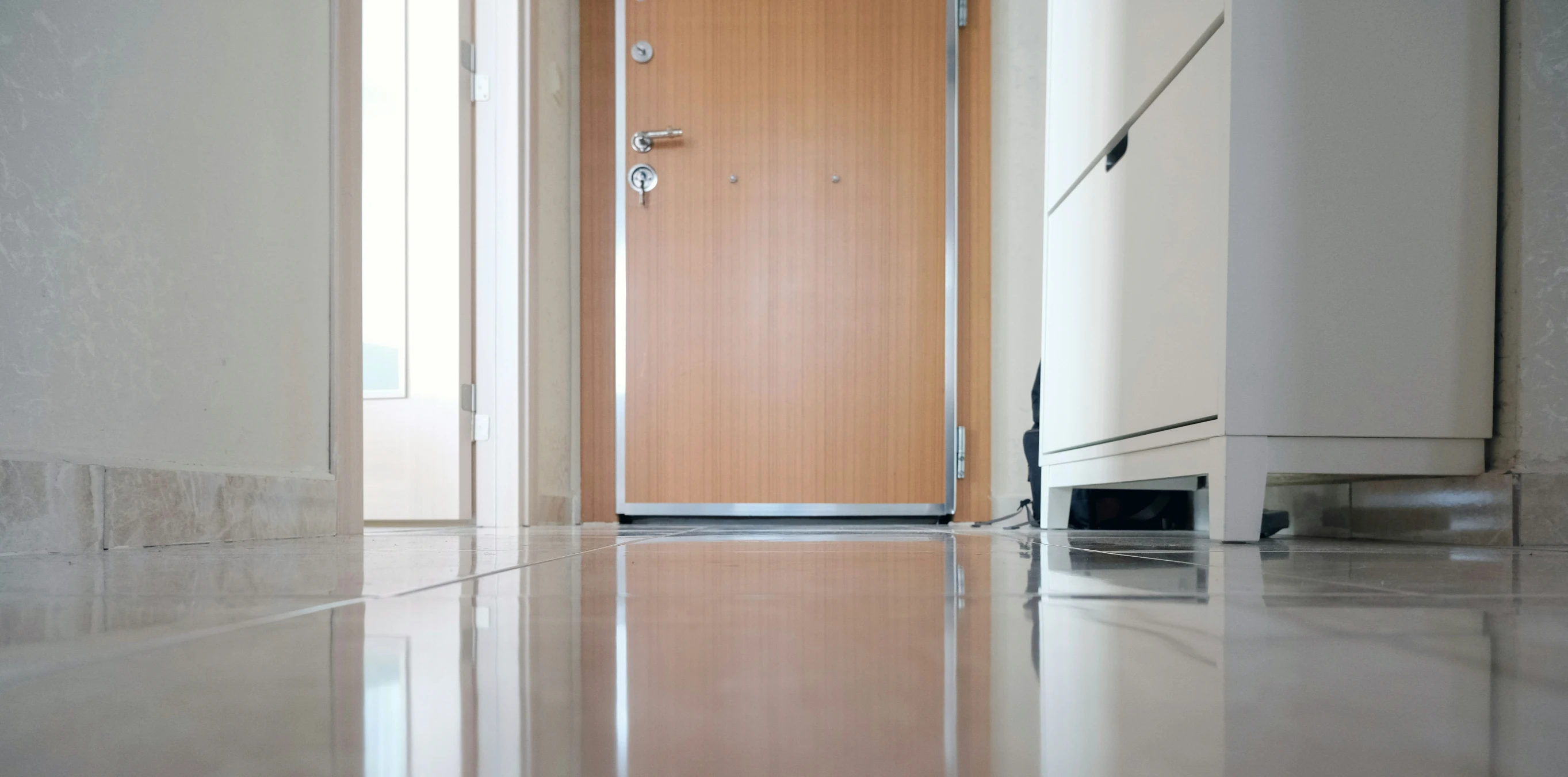 a wooden door and microwave on a shiny metallic floor