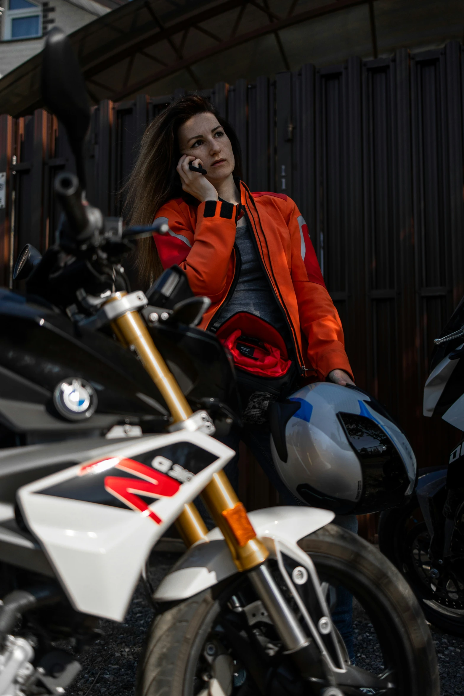 a woman sitting on a motorcycle talking on her cell phone