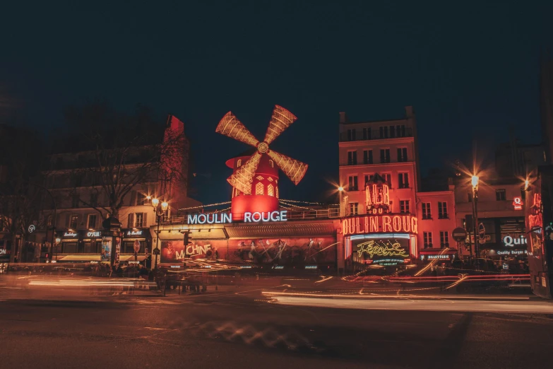 an illuminated street at night with traffic and buildings