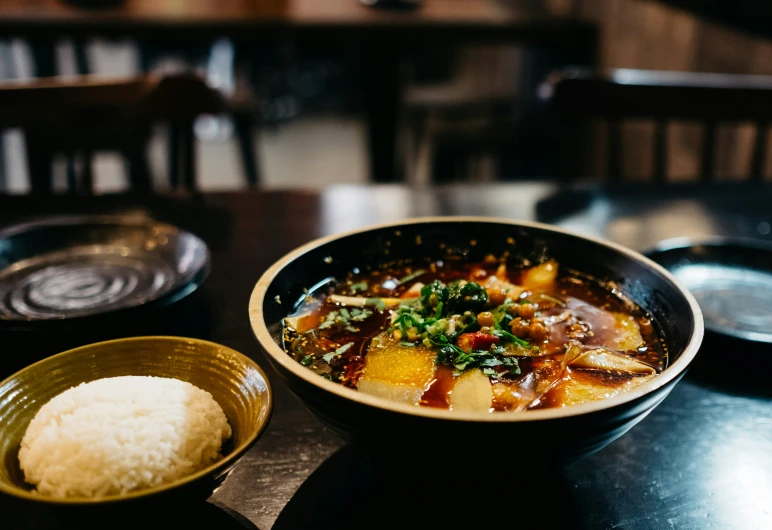 a bowl filled with stew and rice on a table