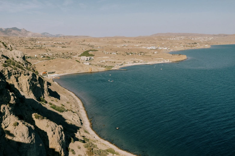 a large body of water sitting below mountains next to a town