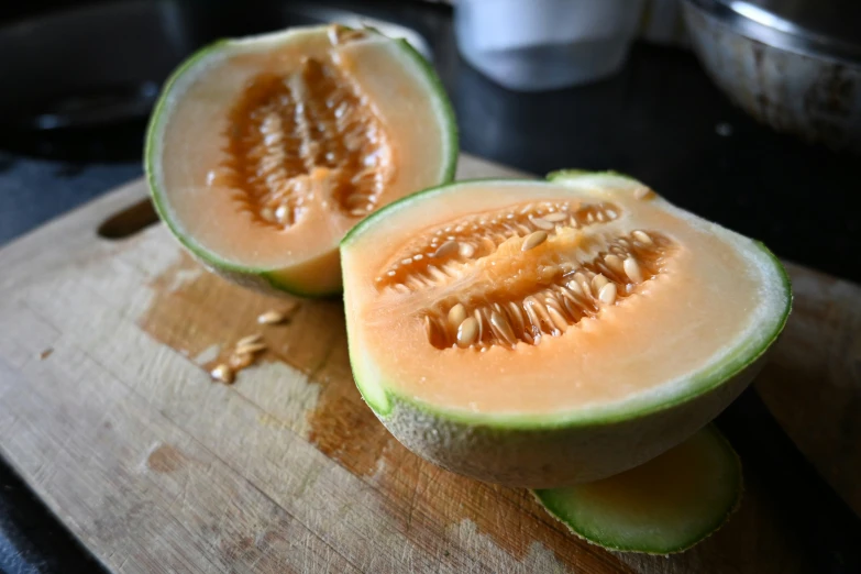the melon is cut in half and placed on a  board