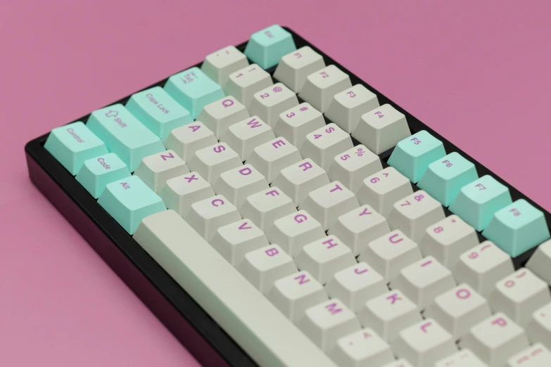 an old gray and blue computer keyboard sits on a pink background