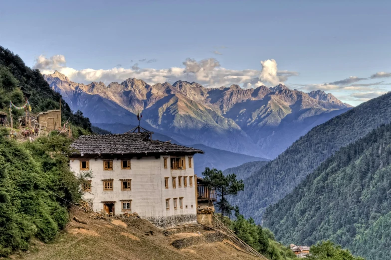 an old house is on the top of a hill