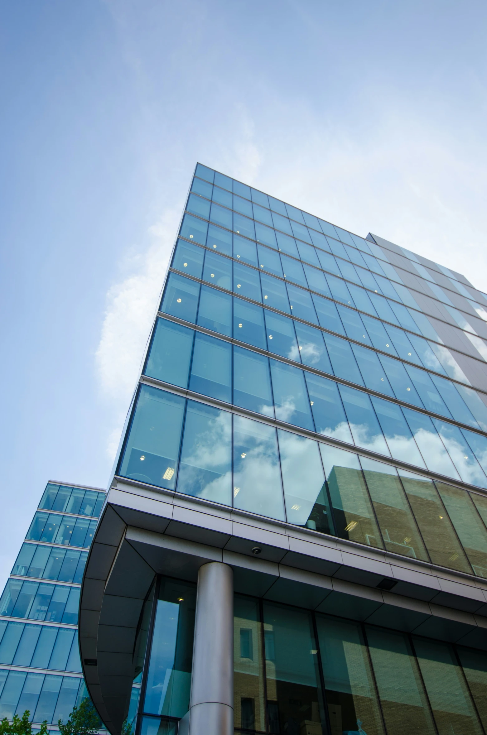 a very tall glass building with sky in the background