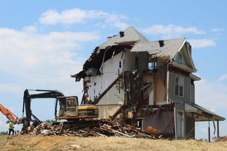 the construction truck is digging into the demolished house