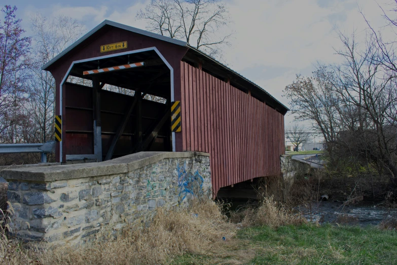 a red covered bridge crosses over a river